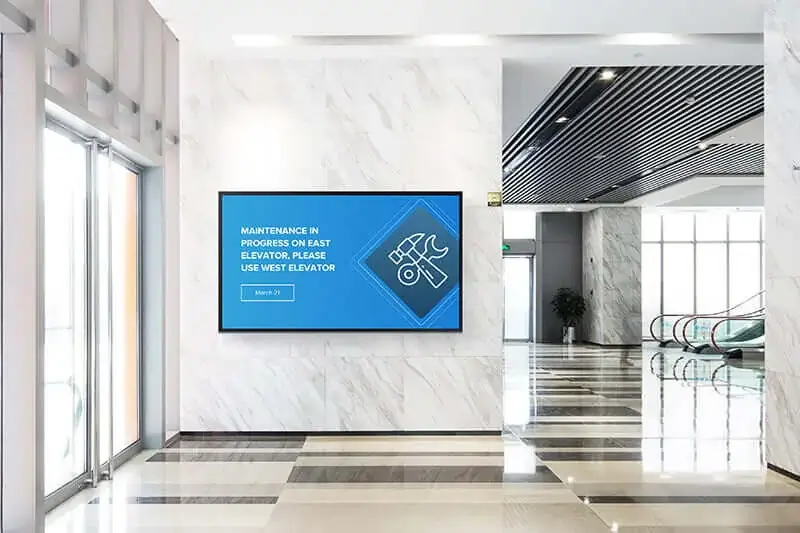 Corporate digital signage screen from Reach Media Network featured in building lobby by entrance, displaying maintenance announcement.