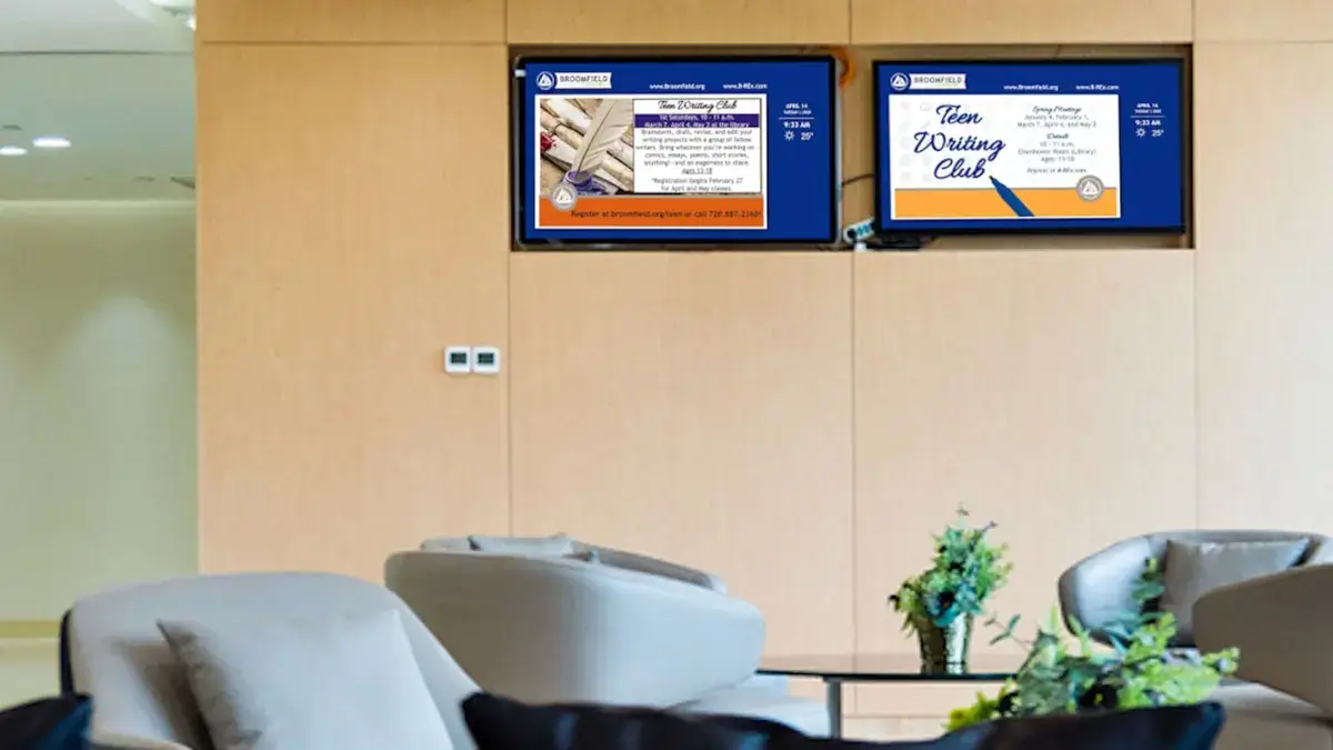 Digital signage screens from Reach Media Network featured in main lobby, displaying announcements and local weather.